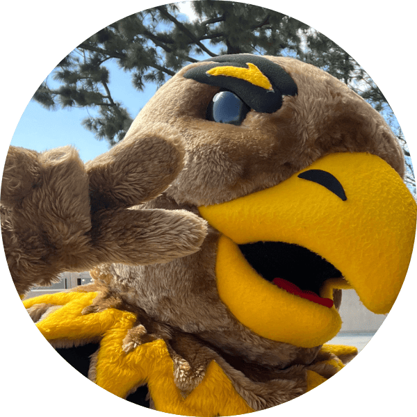 Eddie the Golden Eagle smiling and holding up a peace sign.