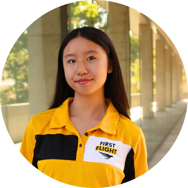 A woman with a yellow and black polo smiling toward the camera.