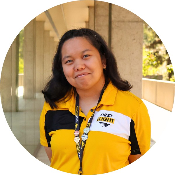 A woman wearing a yellow and black polo shirt smiling at the camera.