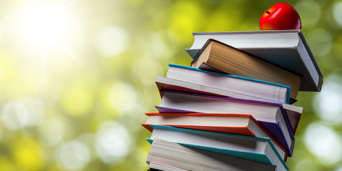 A stack of books with an apple on top.