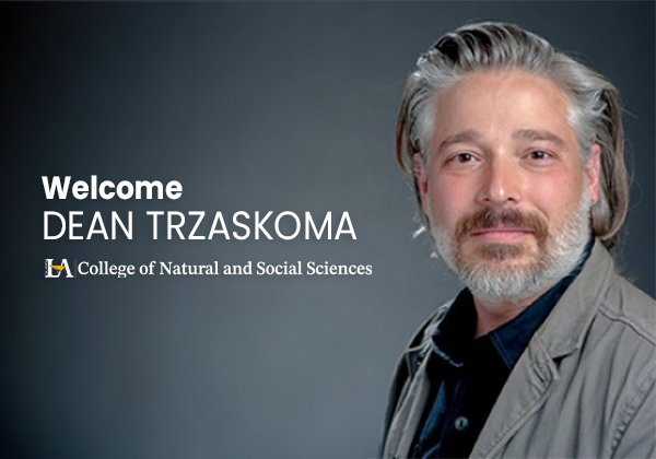 Dr. Stephen Trzaskoma smiles in front of a gray background.