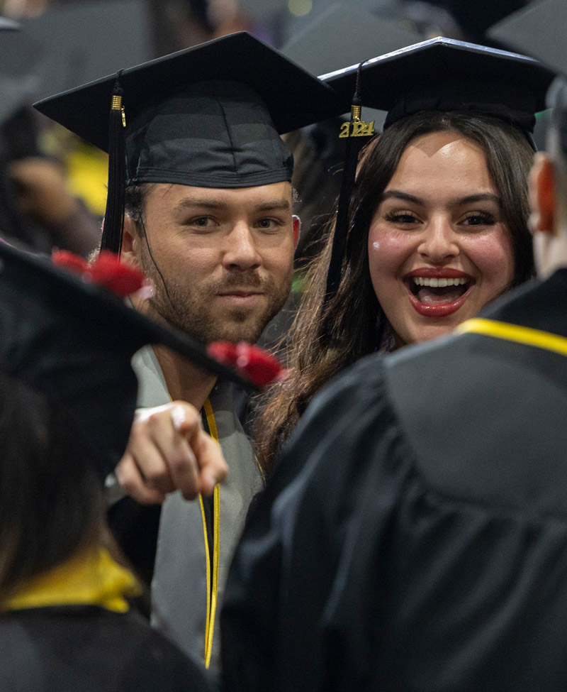 Two graduates celebrating at their graduation ceremony.