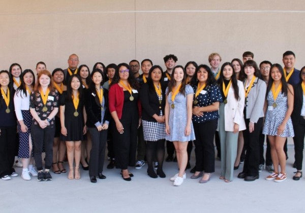 Group picture of all graduating Honors student presenters of the 2023 Honors Thesis Symposium in front of a wall at King Hall.