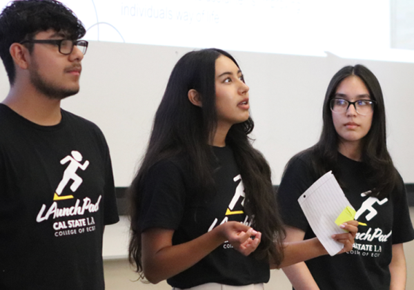 students stand and present to audience 