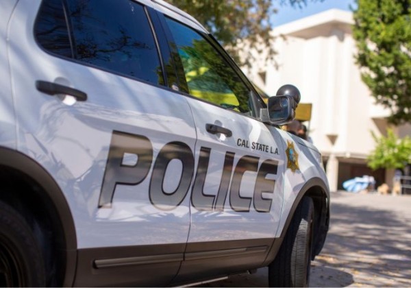 A campus police vehicle is parked outdoors, with the word “POLICE” prominently displayed on the side. 