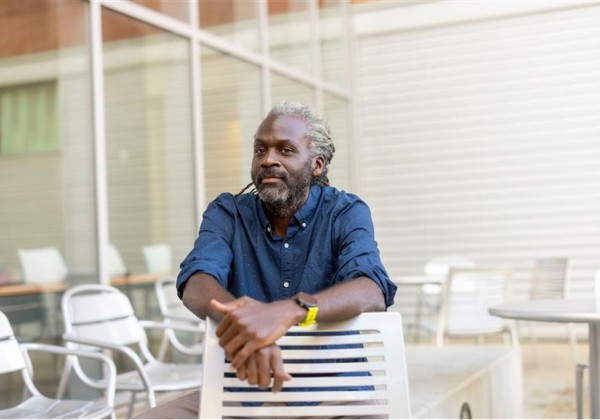 Man posing on chair wearing blue button up