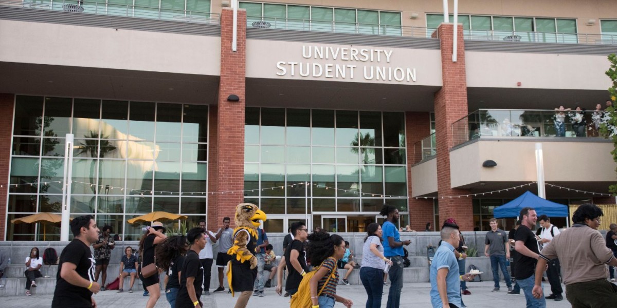 A crowd of students gathers outside a building labeled “University Student Union” 