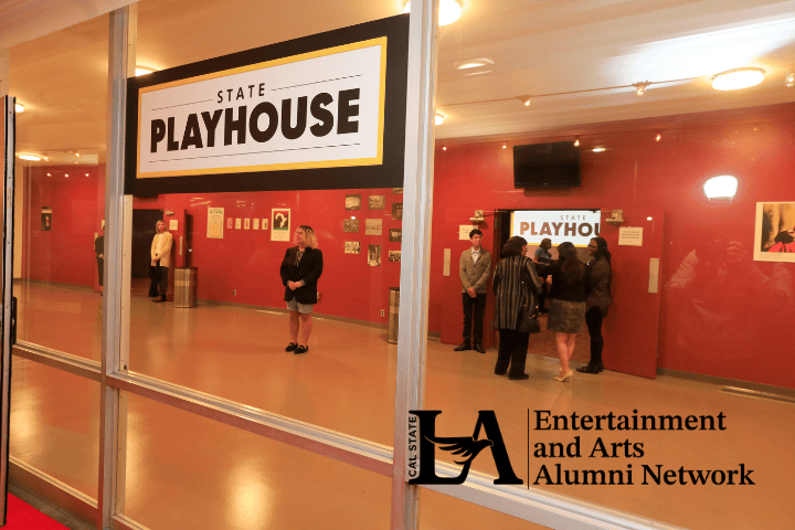 Looking through the windows into the lobby of the Cal State LA State Playhouse. There are people milling about.