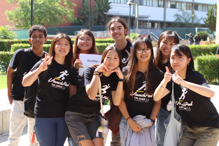 group os students huddle and smile signing thumbs up and heart