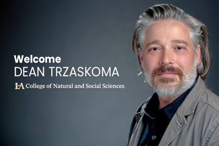 Dr. Stephen Trzaskoma smiles in front of a gray background.
