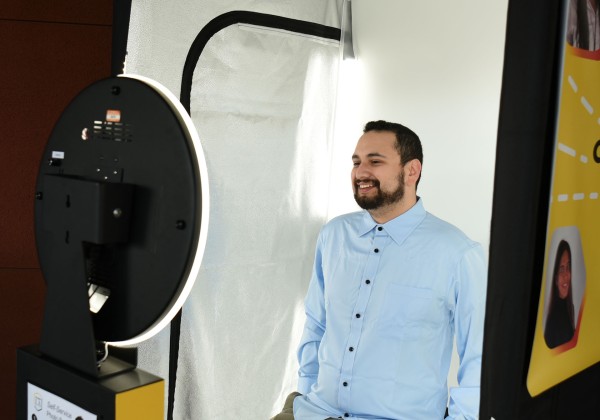 Student smiles confidently while taking professional photo in the Career Photo Booth.