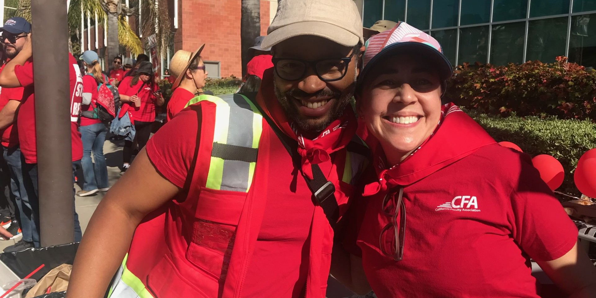 Two CFA strikers posing hugging and smiling.