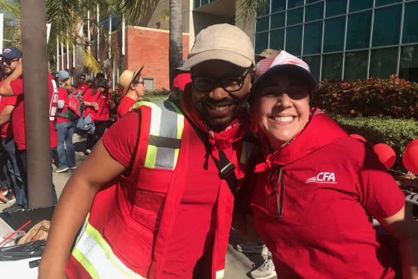 Two CFA strikers posing hugging and smiling.