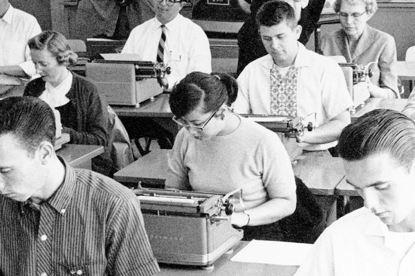 A class of students using typewriters