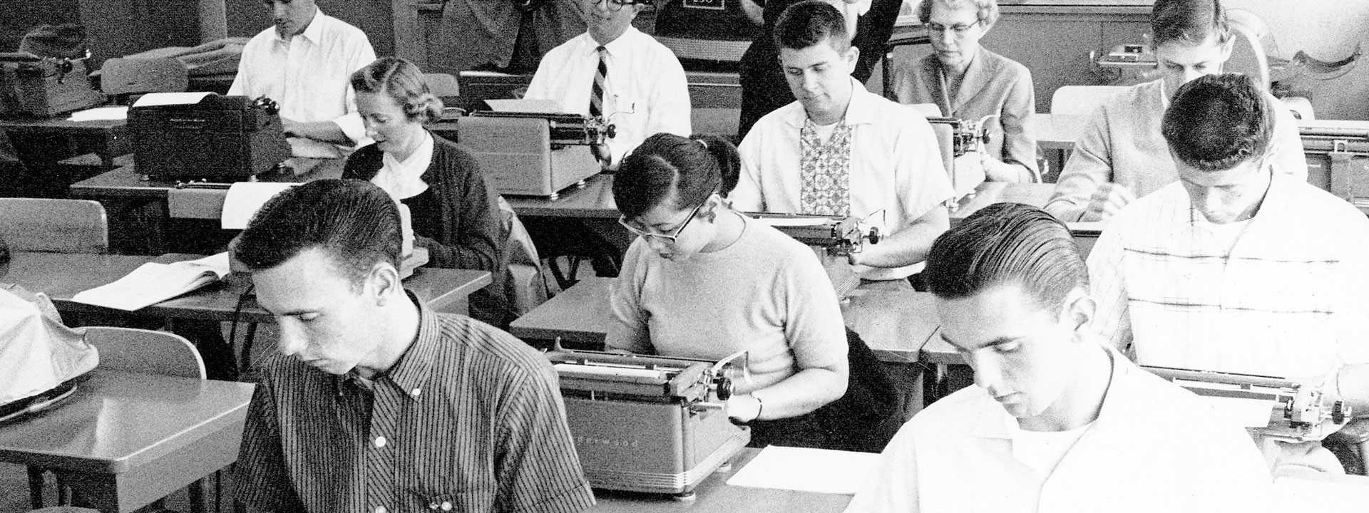 A class of students using typewriters
